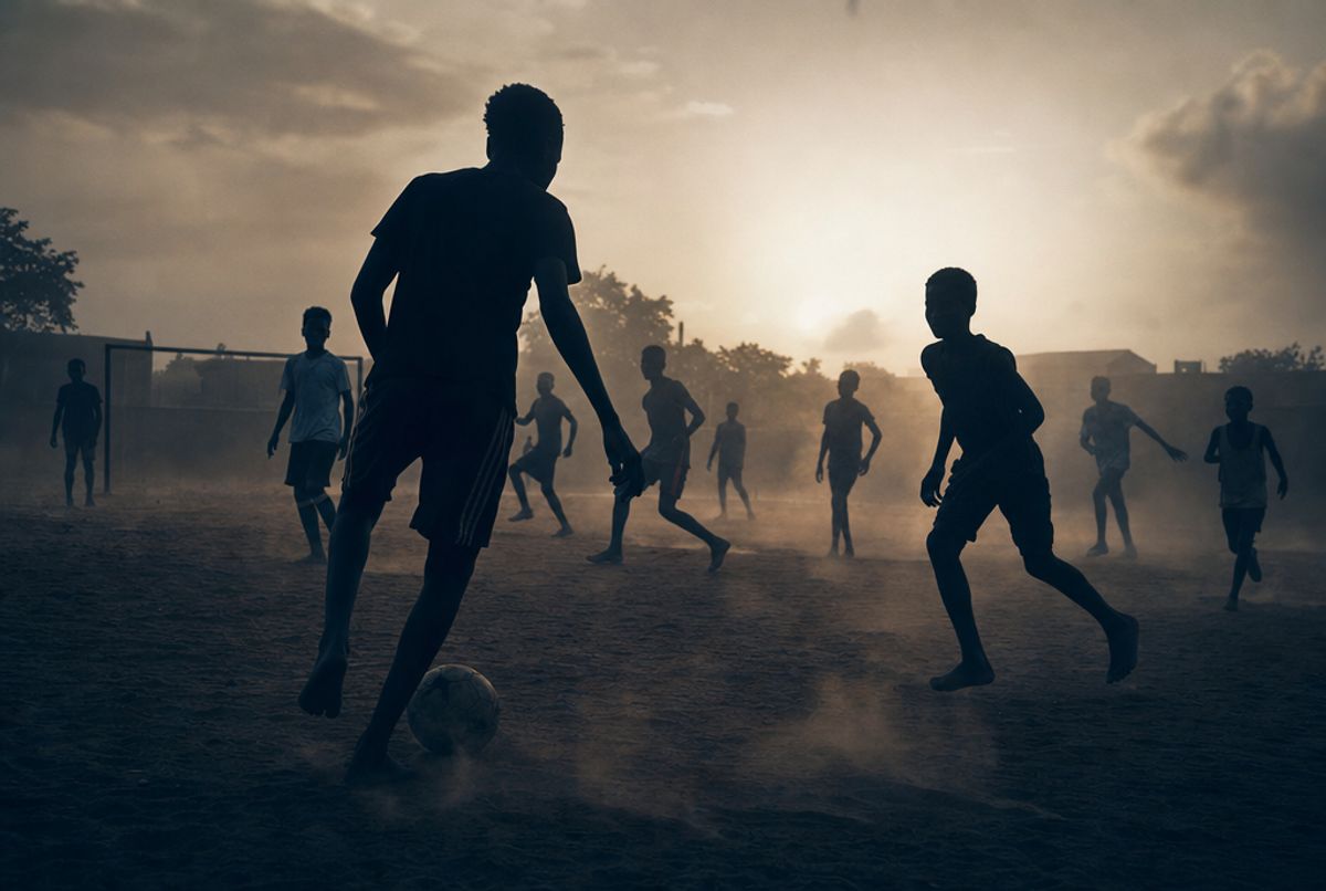 Junge Fußballer im Abendlicht auf einem Platz in Westafrika